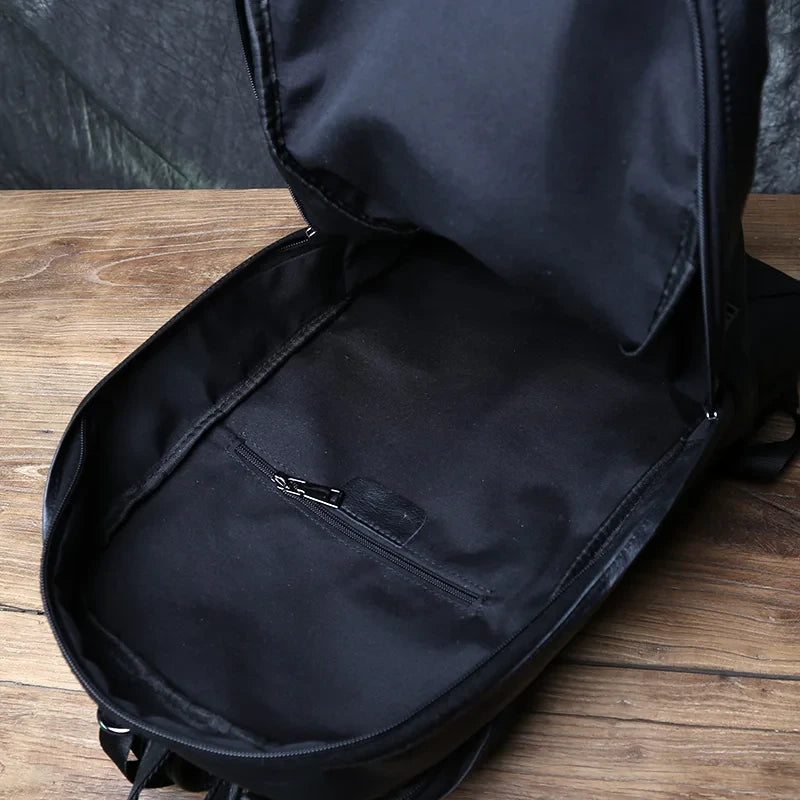 Close-up of a black backpack interiro with spacious compartment and zippered pocket.