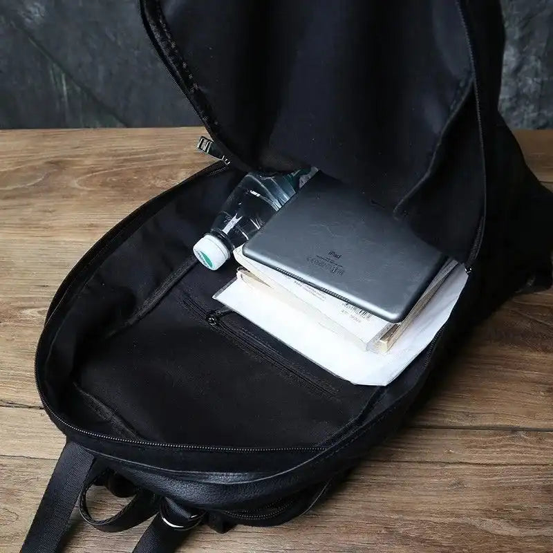 open black backpack, showing items such as a bottle of water, a notebook and sheets of paper.