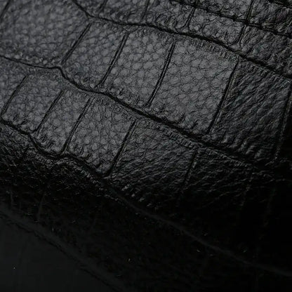 Black crocodile leather texture, highlighting the unique patterns and sophistication of the material. 