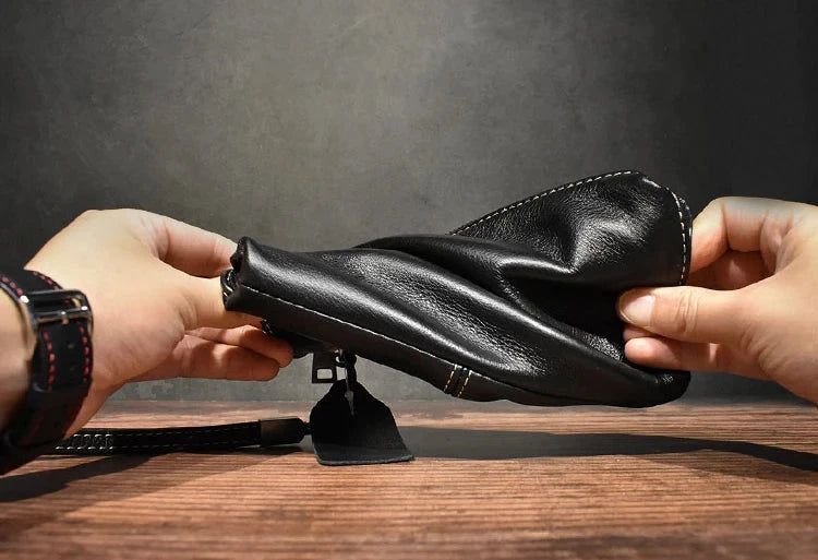 A person demonstrating the flexibility of a black leather wallet.