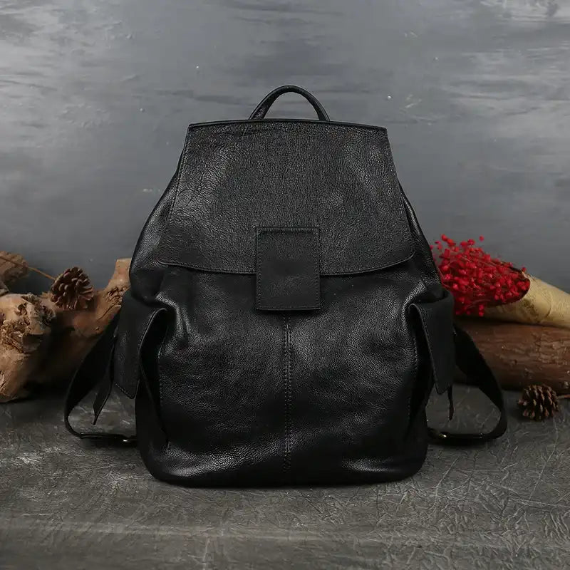 Stylish large black leather backpack with strap and handle in a minimalist design, front view.