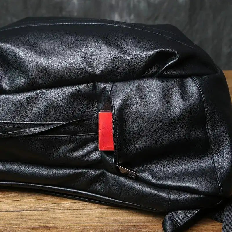 Detail of a black leather backpack external zipper side pocket.
