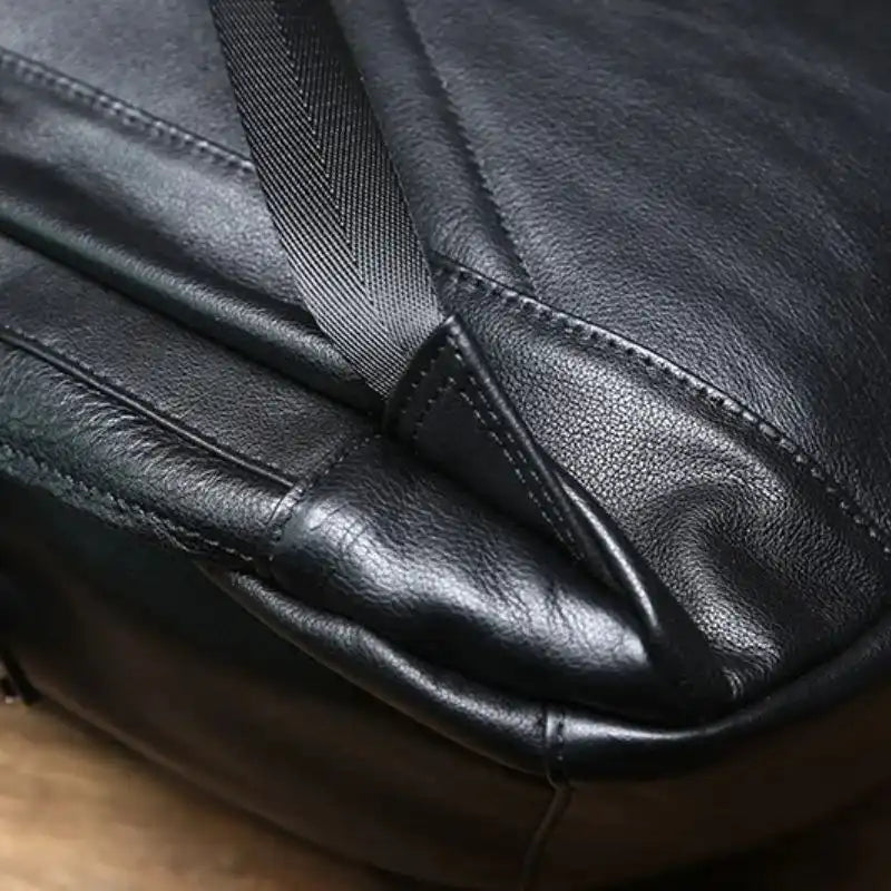 Detail of an elegant black bag, showing off the durable texture and sturdy strap attachment.