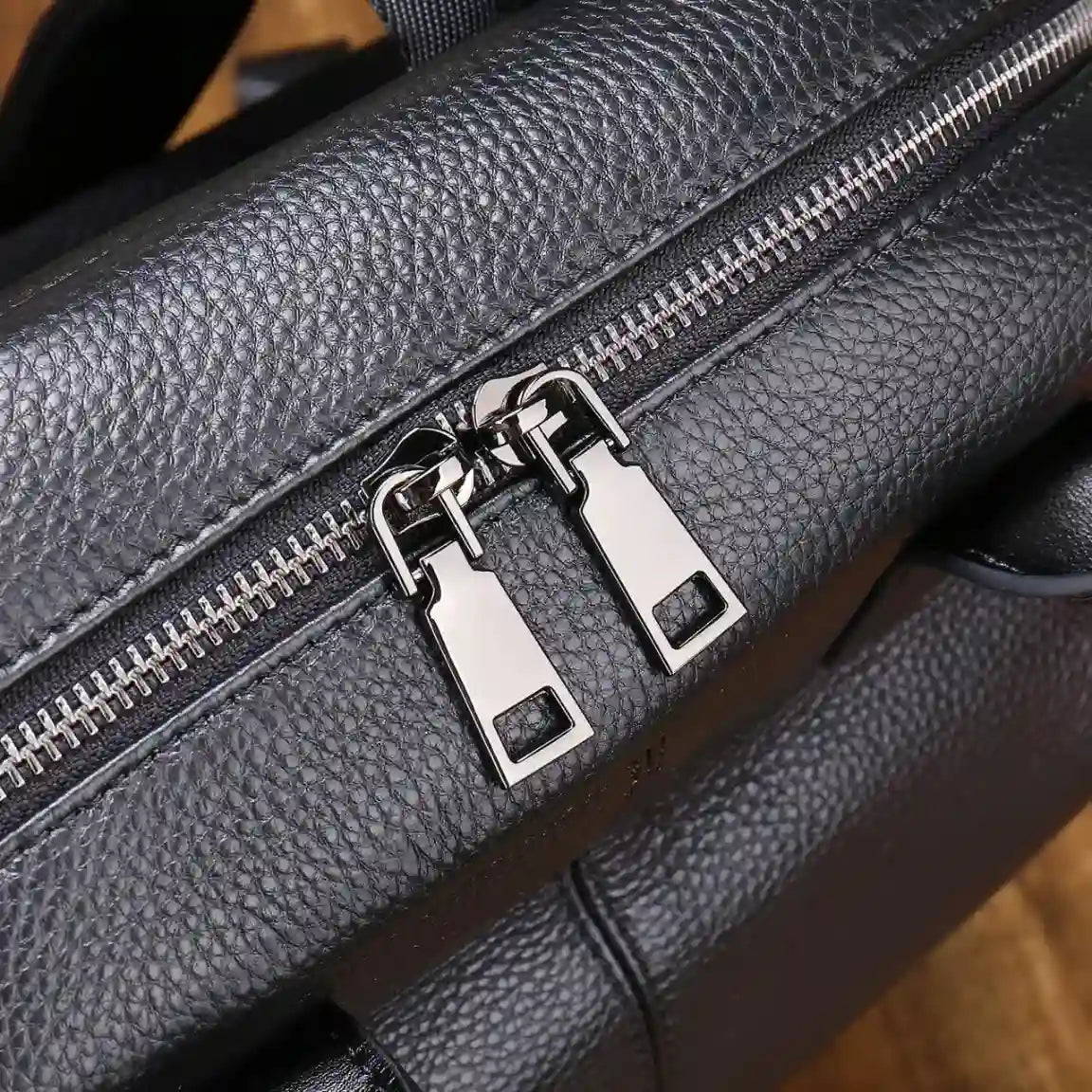 Stylish black leather bag featuring a dual zipper closure.