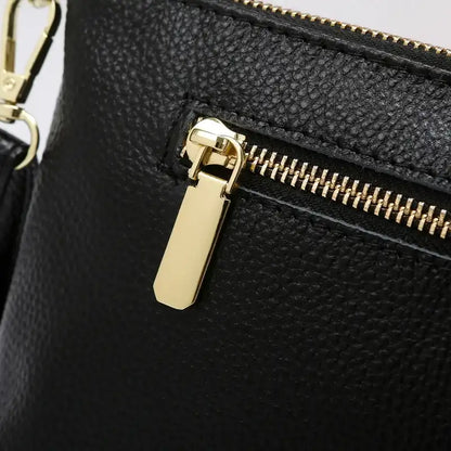 Detail of a black leather bag with a gold zipper, highlighting the texture and elegance of the material.
