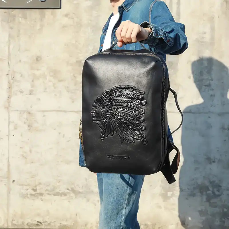 Stylish black leather backpack featuring an Indian chief embossed design - front view.