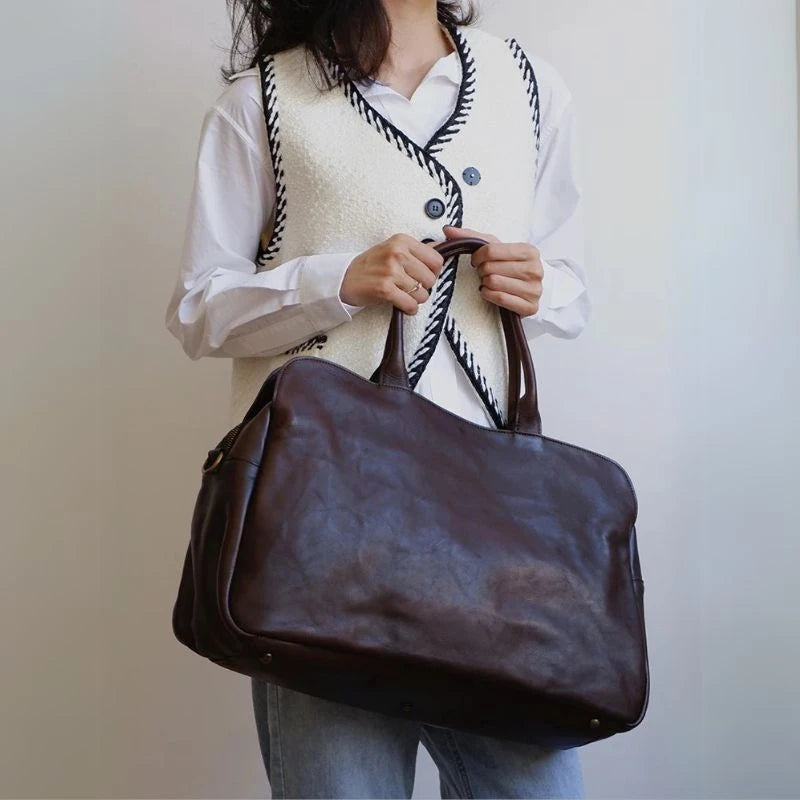 A stylish woman holding by hand a black leather bag with style.