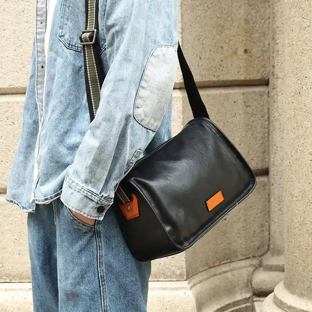 black leather shoulder bag worn by a model wearing a denim shirt showing style and practicality.