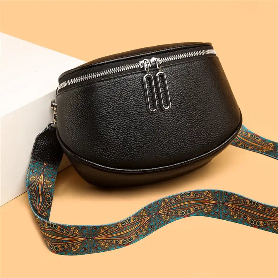Stylish black leather shoulder bag with decorative handle and silver zippers.