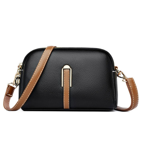 Chic black leather crossbody bag featuring a gold accent and a brown strap - front view.