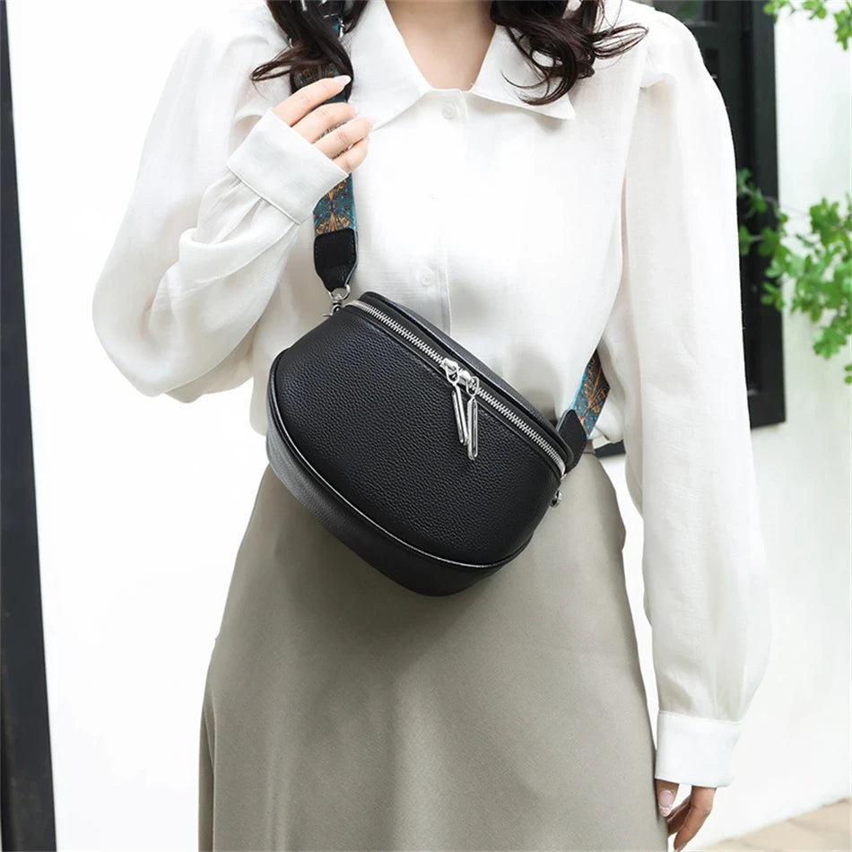 a woman wearing an elegant black leather shoulder bag with colored  strap across the body.