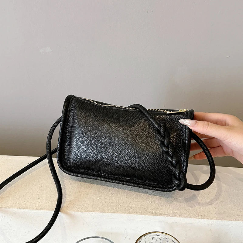 Stylish black leather crossbody bag with braided strap - front view