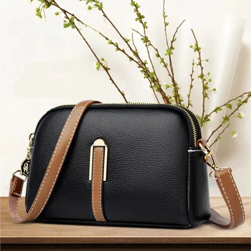 Chic modern leather handbag featuring a sleek design and gold accents.