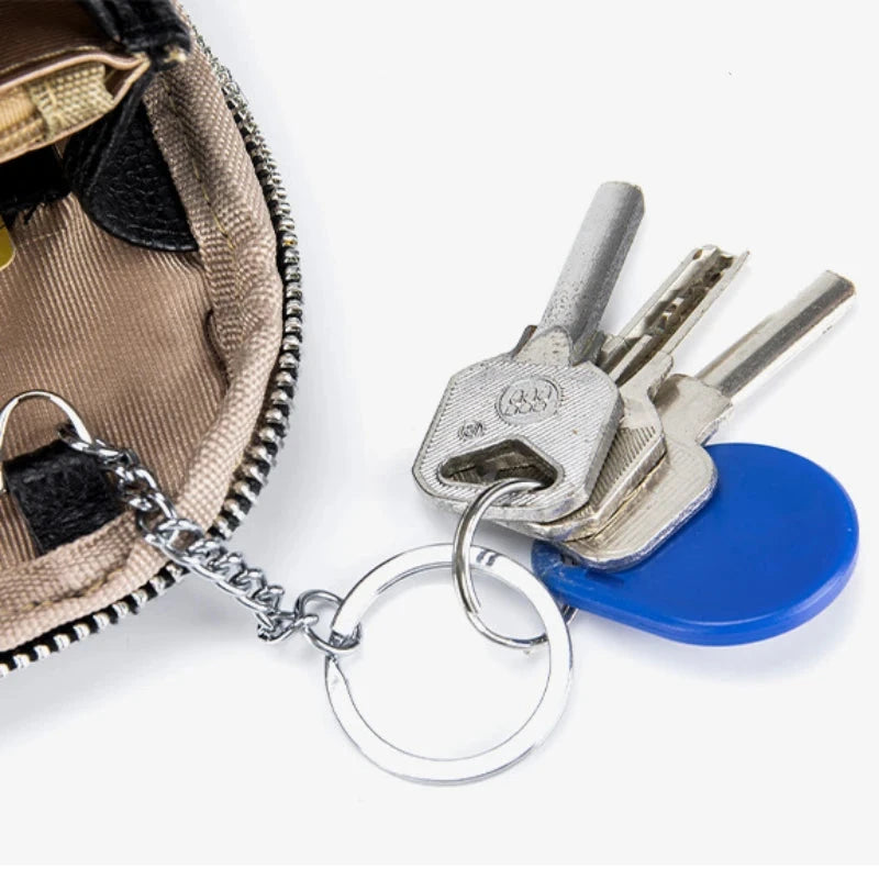close-up view of keys hanging from a keychain inside a zipper leather bag.