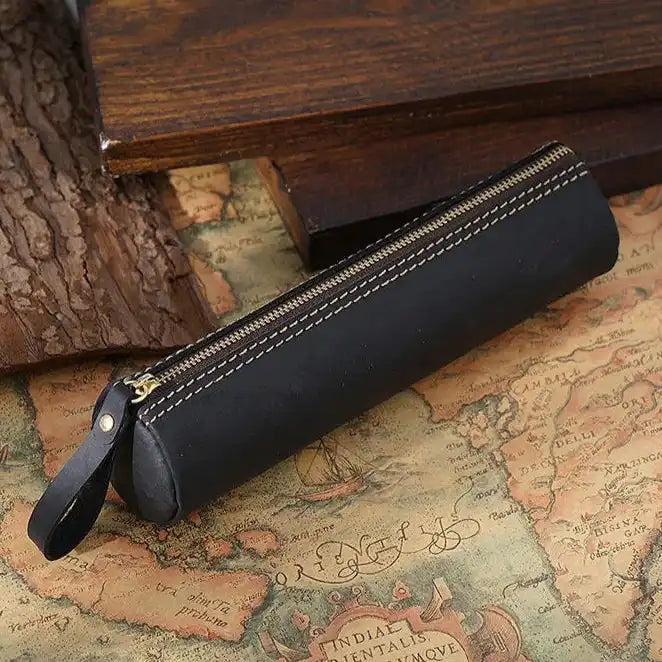 Elegant black leather pen case on an antique map, front view.