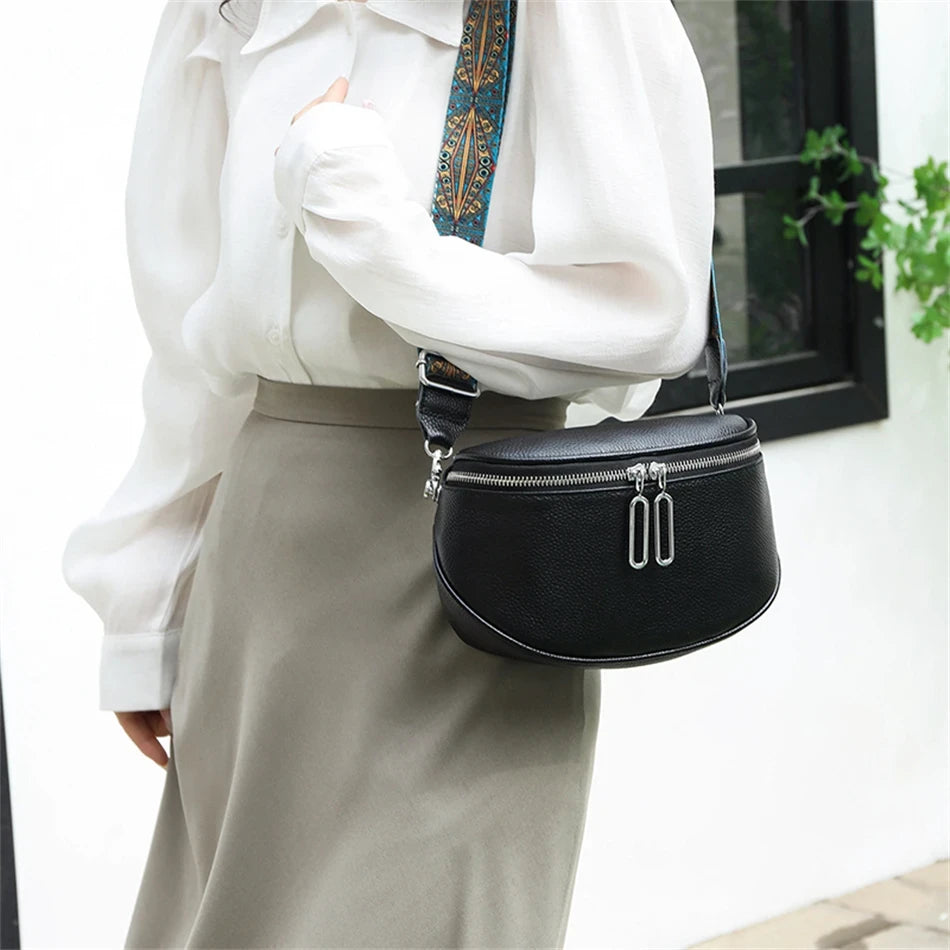 a woman wearing an elegant black leather shoulder bag with colored patterned strap. 
