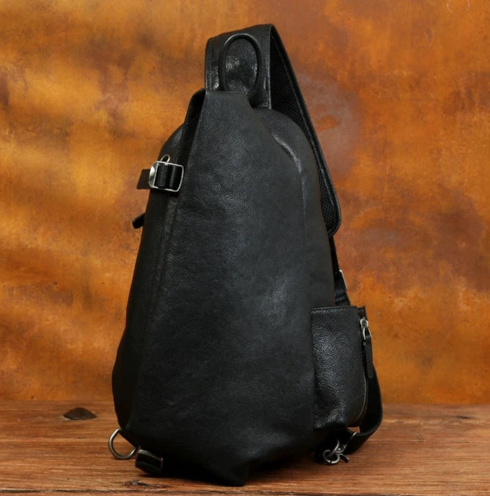 Black leather shoulder bag with a modern organic shape and elegant design, front view.