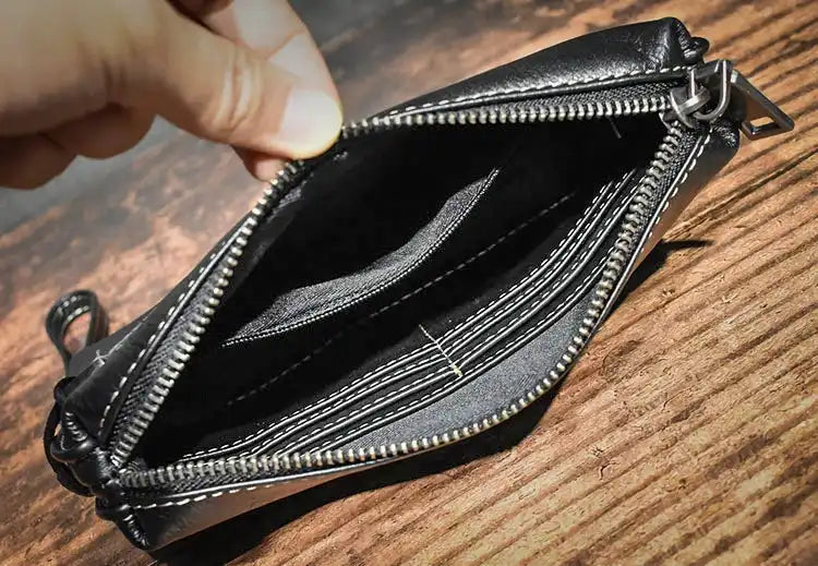 Stylish zippered black leather wallet being opened to reveal its compartments.