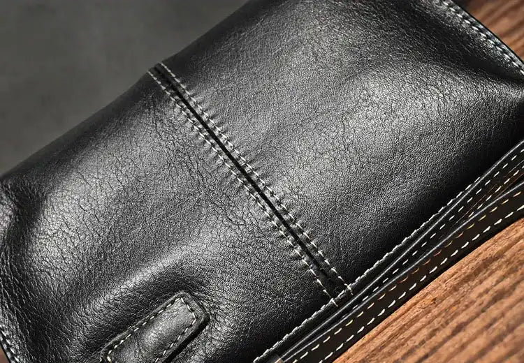 Close-up view of a black leather wallet with detailed stitching.