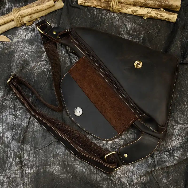 Open view of a leather crossbody bag showcasing its interior and zipper.