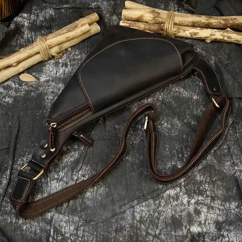Stylish vintage black leather sling bag with a unique triangular design.