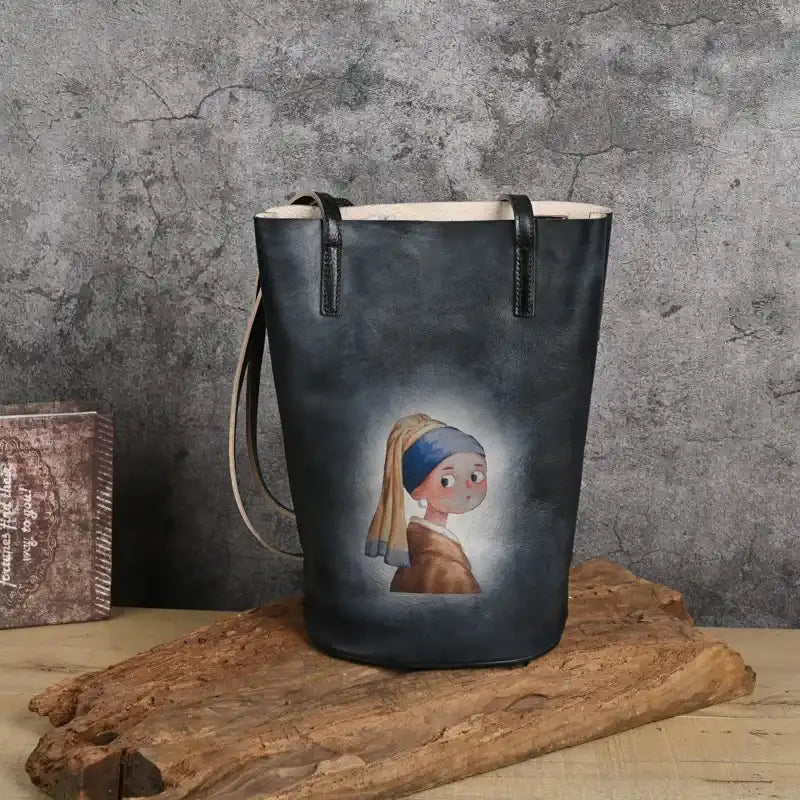 black leather tote bag with artwork of the girl with the pearl earring, front view.