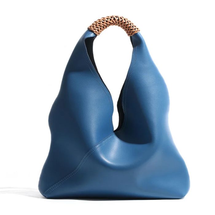 Blue color leather bag with unique design and braided handle, front view.