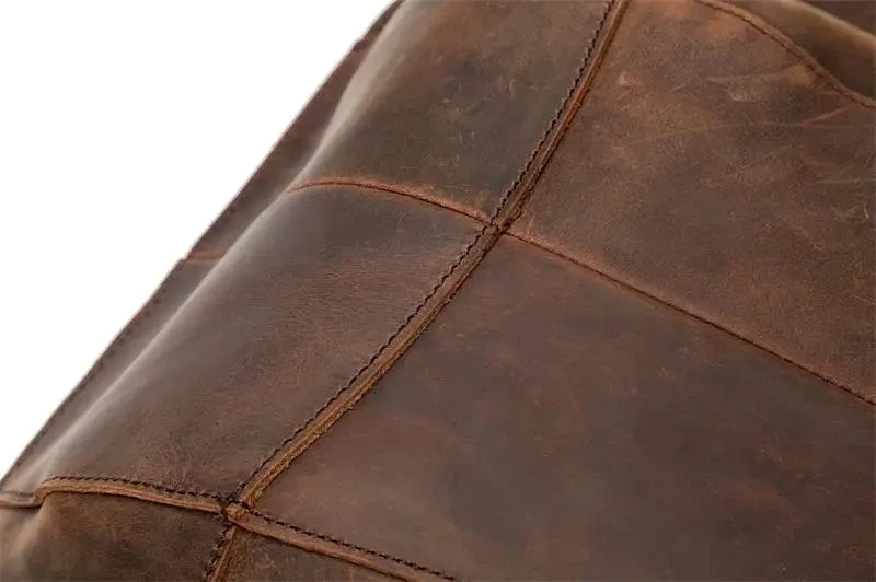 Detail of a brown leather bag, showing the finish and refined stitching.