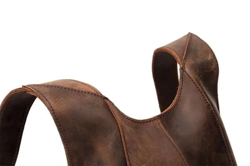 Detail of a brown leather backpack highlighting the texture of the material and straps design.
