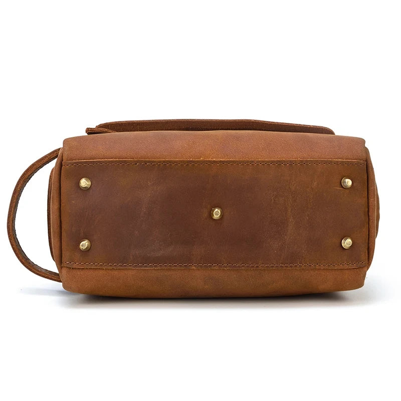 bottom view of a brown leather clutch with metal studs.