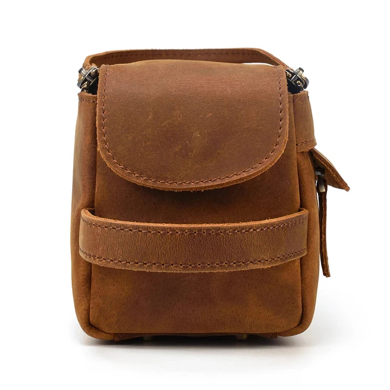 Front view of a brown leather clutch with a flap and zipper.