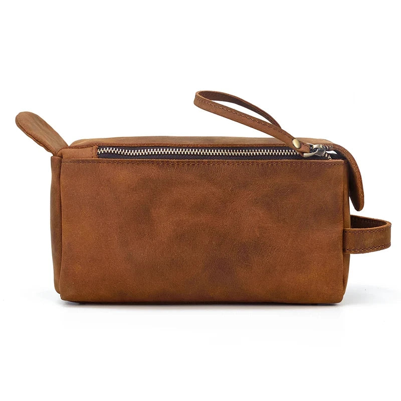 side view of a brown leather clutch with a flap and zipper.