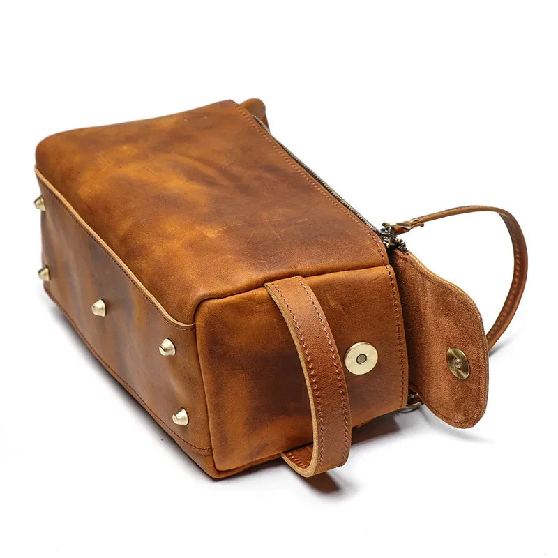 Stylish vintage leather toiletry bag with studs, zipper and side handle.