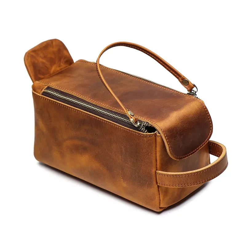 Brown leather clutch with handle, ideal for storing personal items and makeup, highlighting the sophistication of the material.