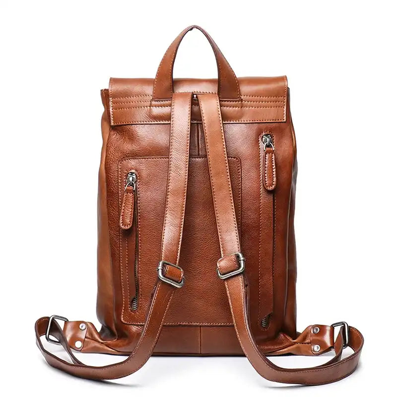 back view of a vintage brown leather backpack with adjustable straps, soft handle and zipper pockets.