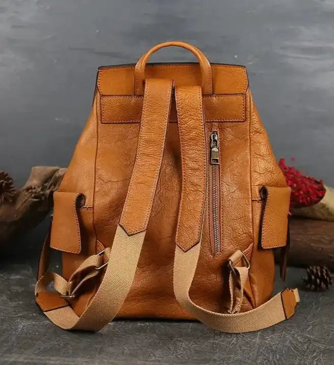 brown leather backpack with adjustable straps and back zipper pocket, back view.