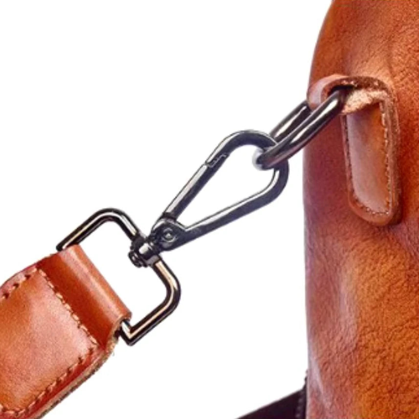 Detail of metal clasp and leather handle on bag, showing quality and elegant design.