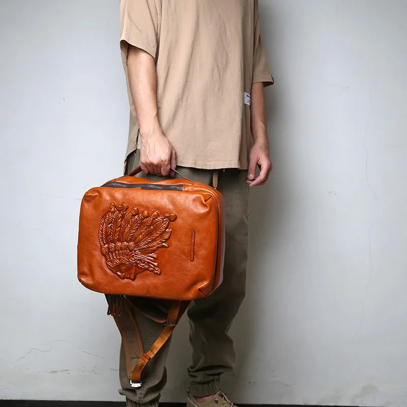 Man holding a brown leather backpack with indigenous chief embossed print.