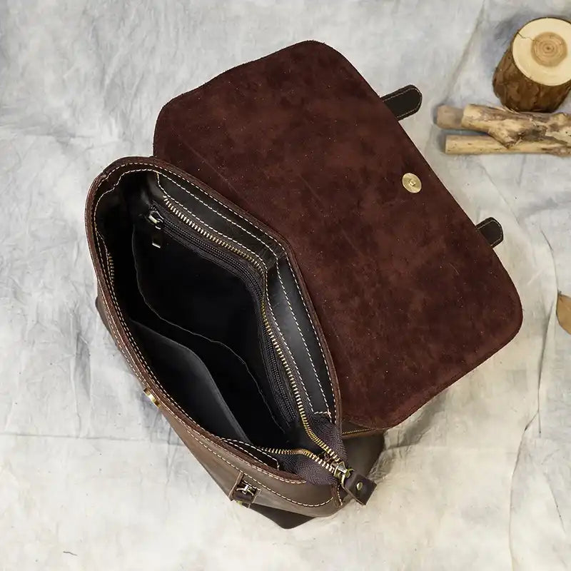interior view of a brown leather bag with suede accents featuring multiple compartments and a zipper closure.