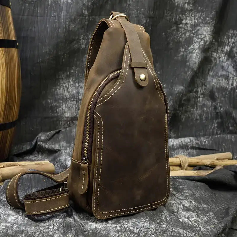 Front view of a brown leather sling bag showcasing its design and stitching.