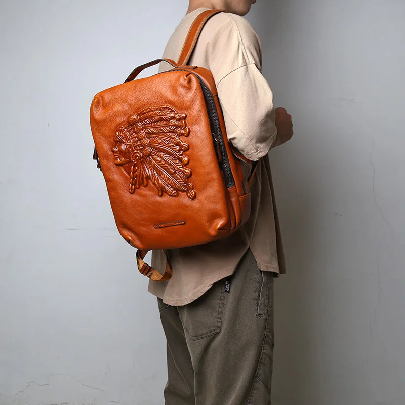 Man wearing on his shoulder, a brown leather backpack with indigenous chief embossed print.