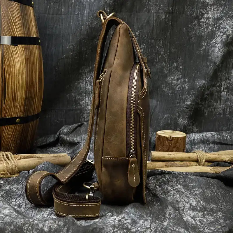 Stylish brown leather bag with stitching details and an adjustable strap, side view.