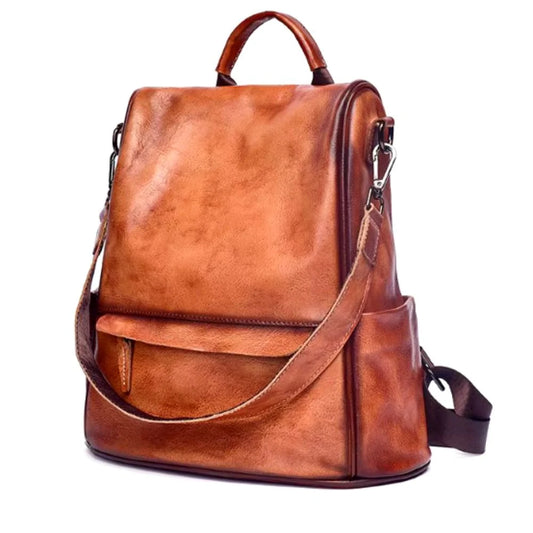 Vintage-inspired brown leather backpack with detachable strap and soft handle, front view.