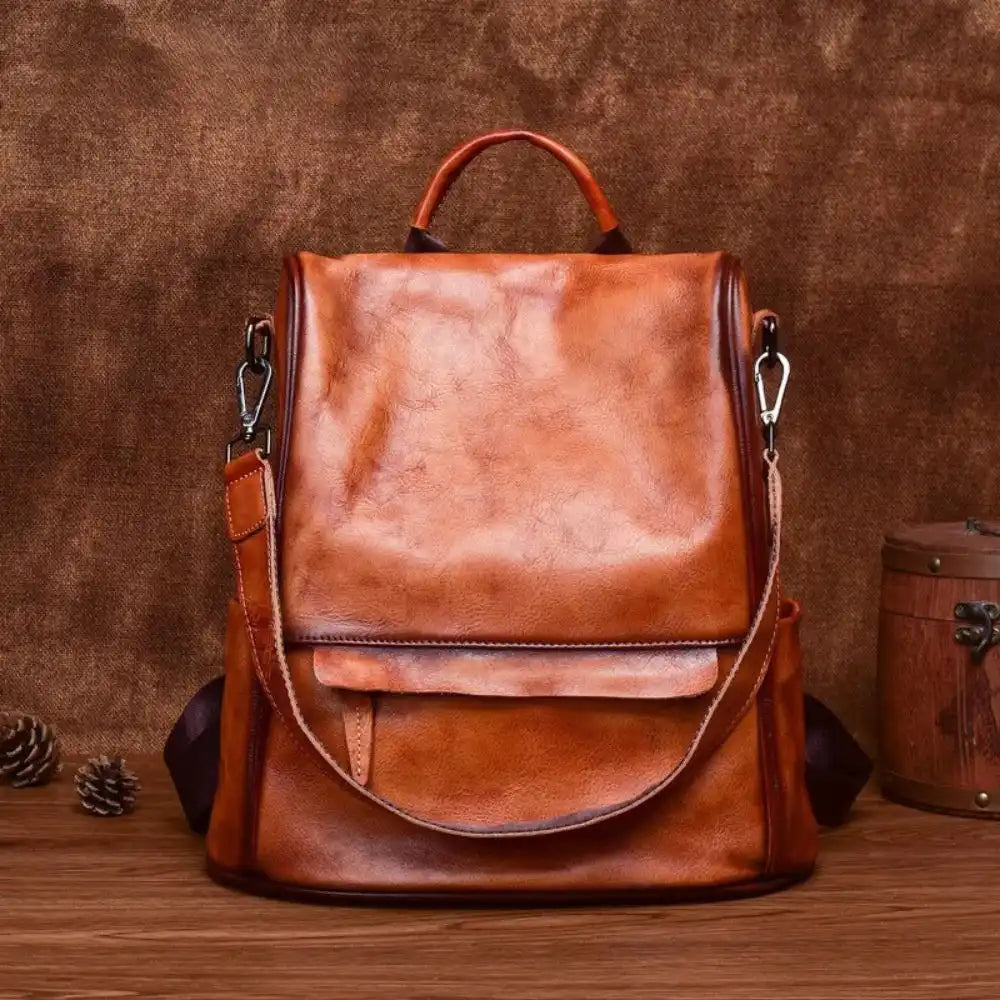 Vintage-inspired brown leather backpack with anti-theft design, detachable strap and soft handle, front view.