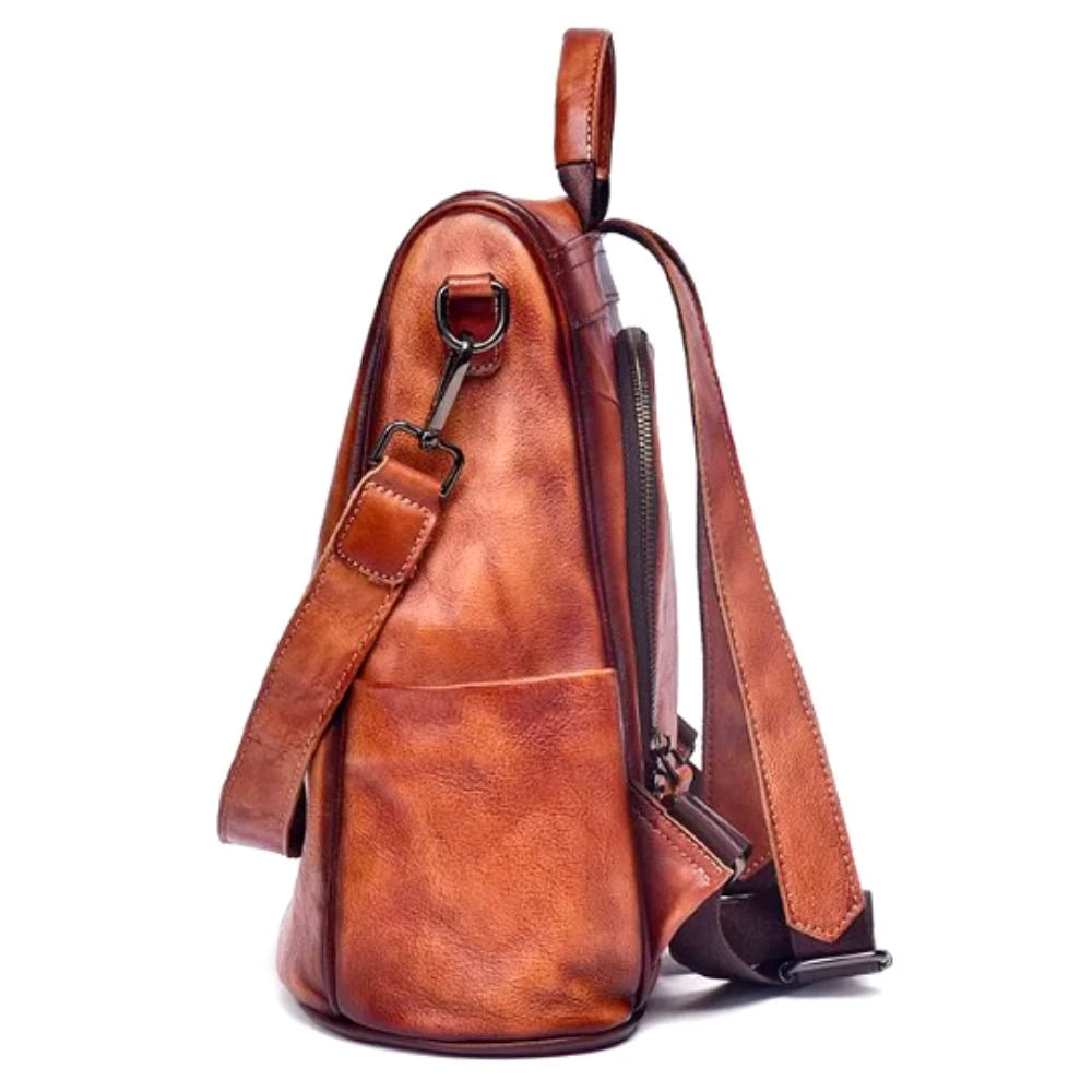 Vintage-inspired brown leather backpack with durable back straps  and side pocket, side view.