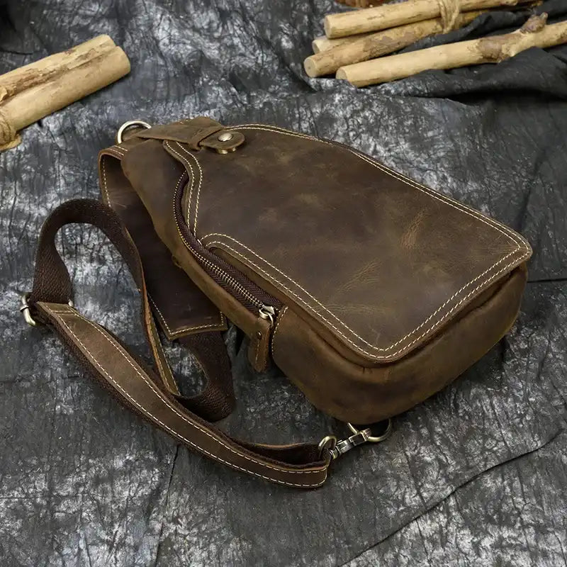 Stylish brown leather bag, with stitching details and an adjustable strap, top view.