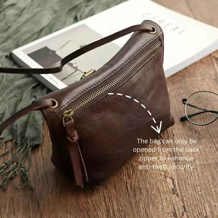 back view of a brown leather crossbody bag showing back zipper compartment to enhance antitheft security.