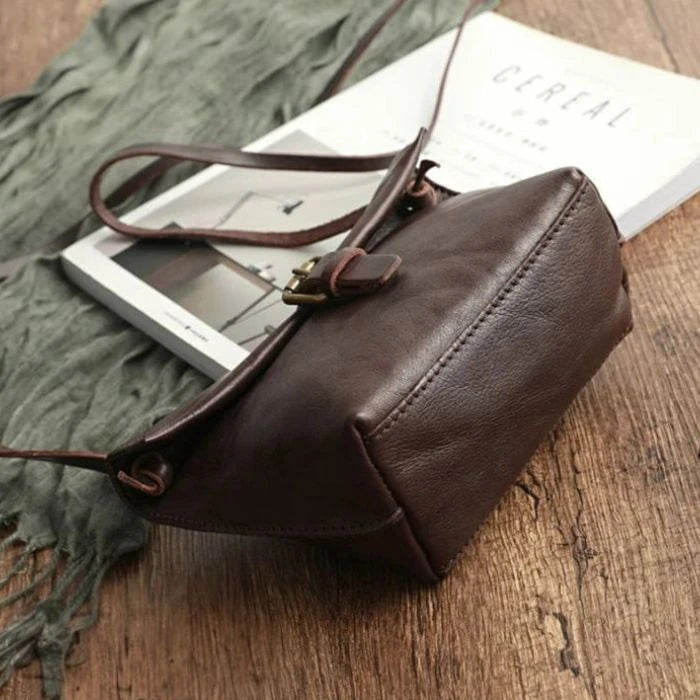 bottom view of a brown leather crossbody bag highlighting the material quality and fine stitching.