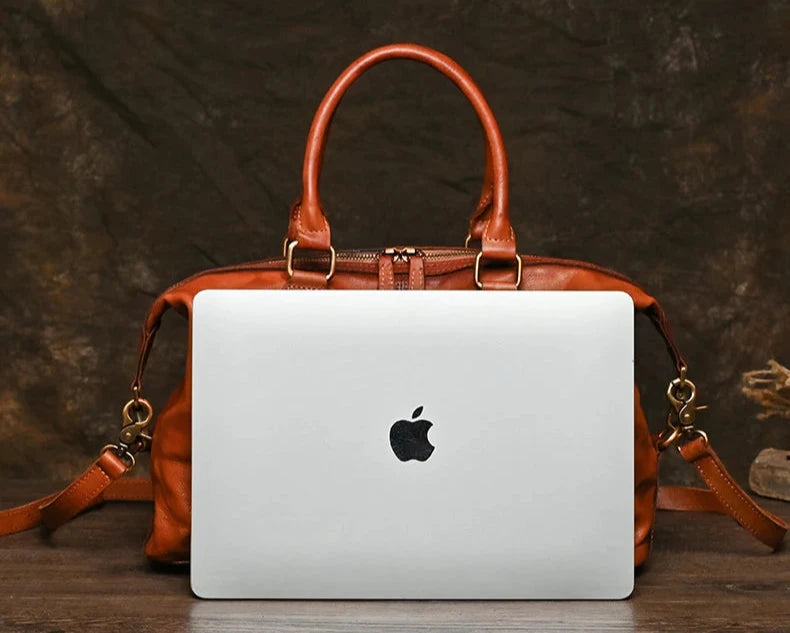 brown leather bag with a laptop on the front for size reference, front view.