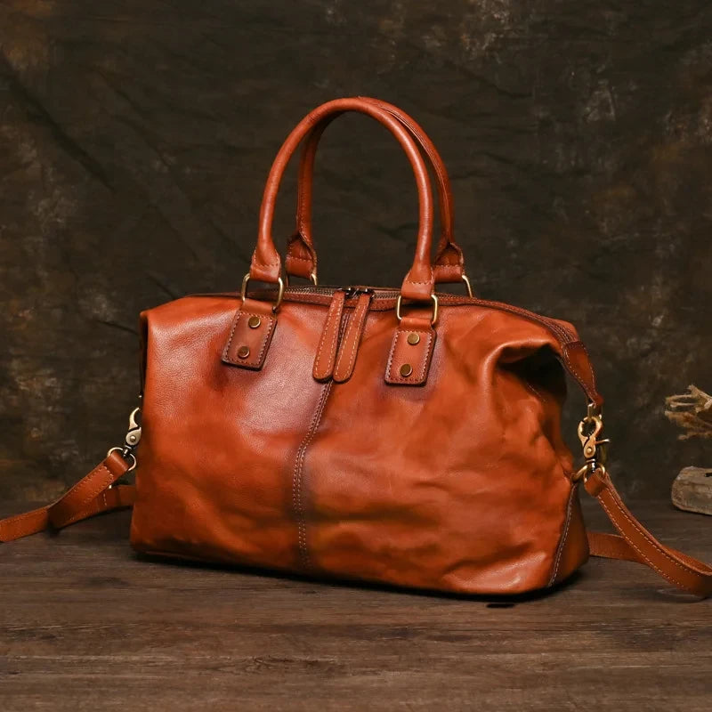 Vintage style brown leather bag with handles and zipper compartment, front view. 